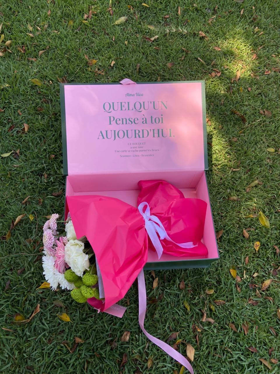 Ramo envuelto en papel fucsia dentro de la caja insignia Alma Viva